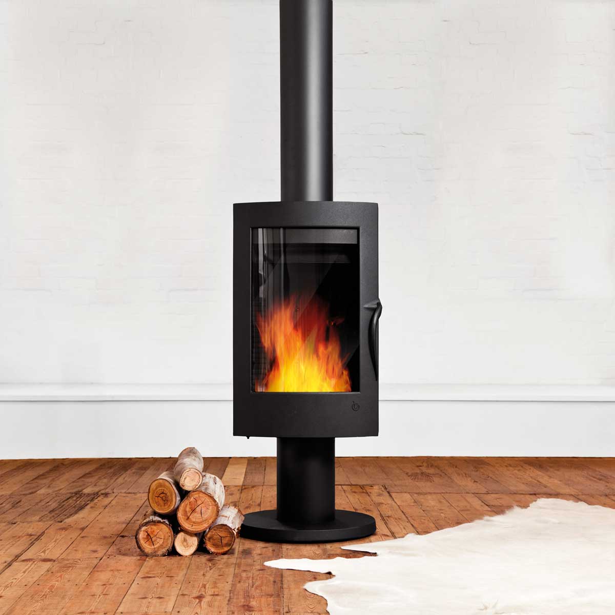 Invicta Pharos wood heater in minimalist room with white walls and timber floor