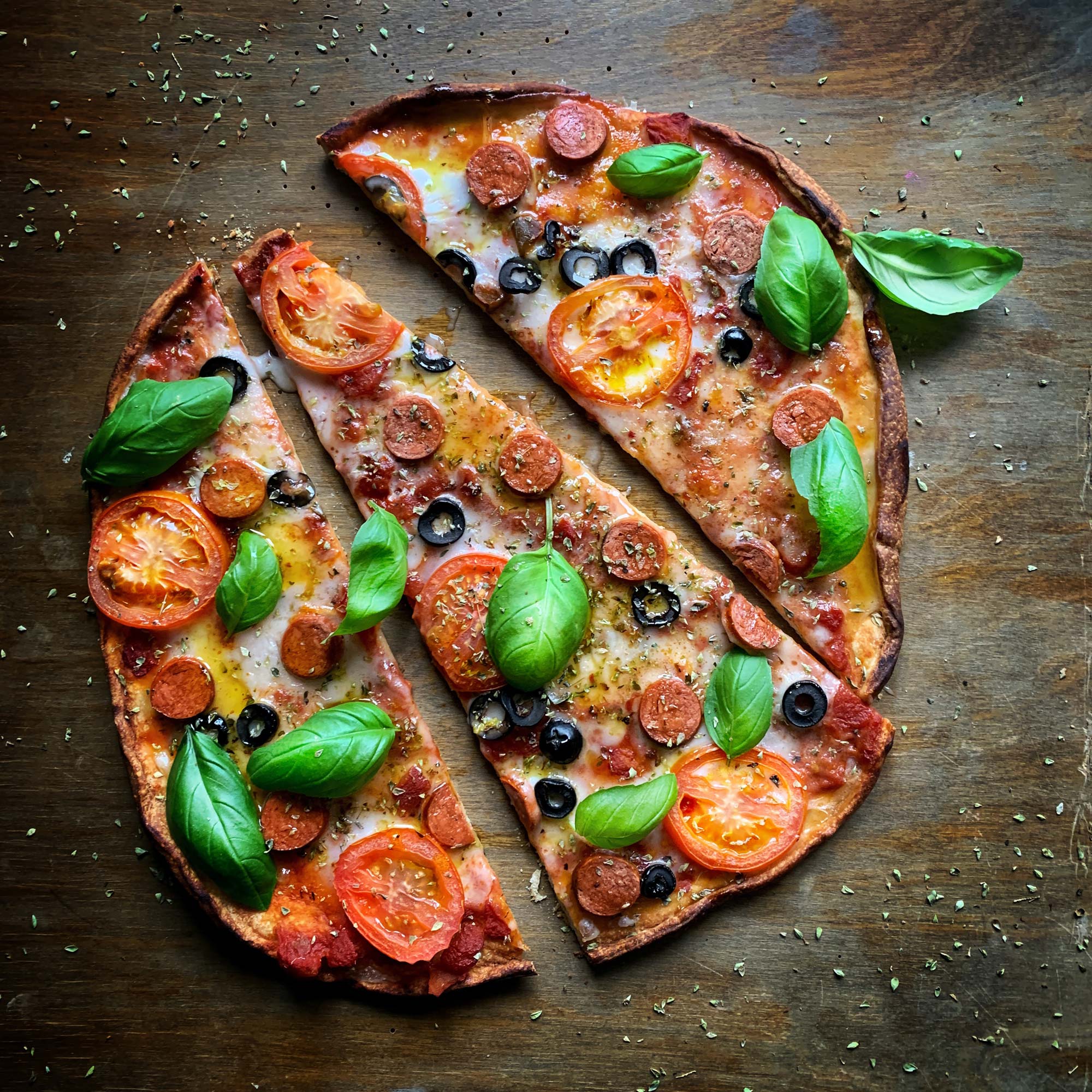Wood fired pizza with tomatoes, basil, pepperoni and olives