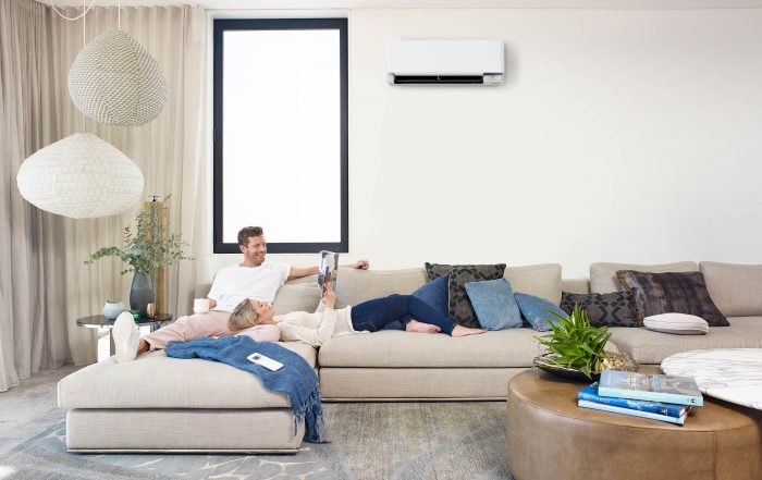 Couple relaxing in lounge room with split system air conditioner on
